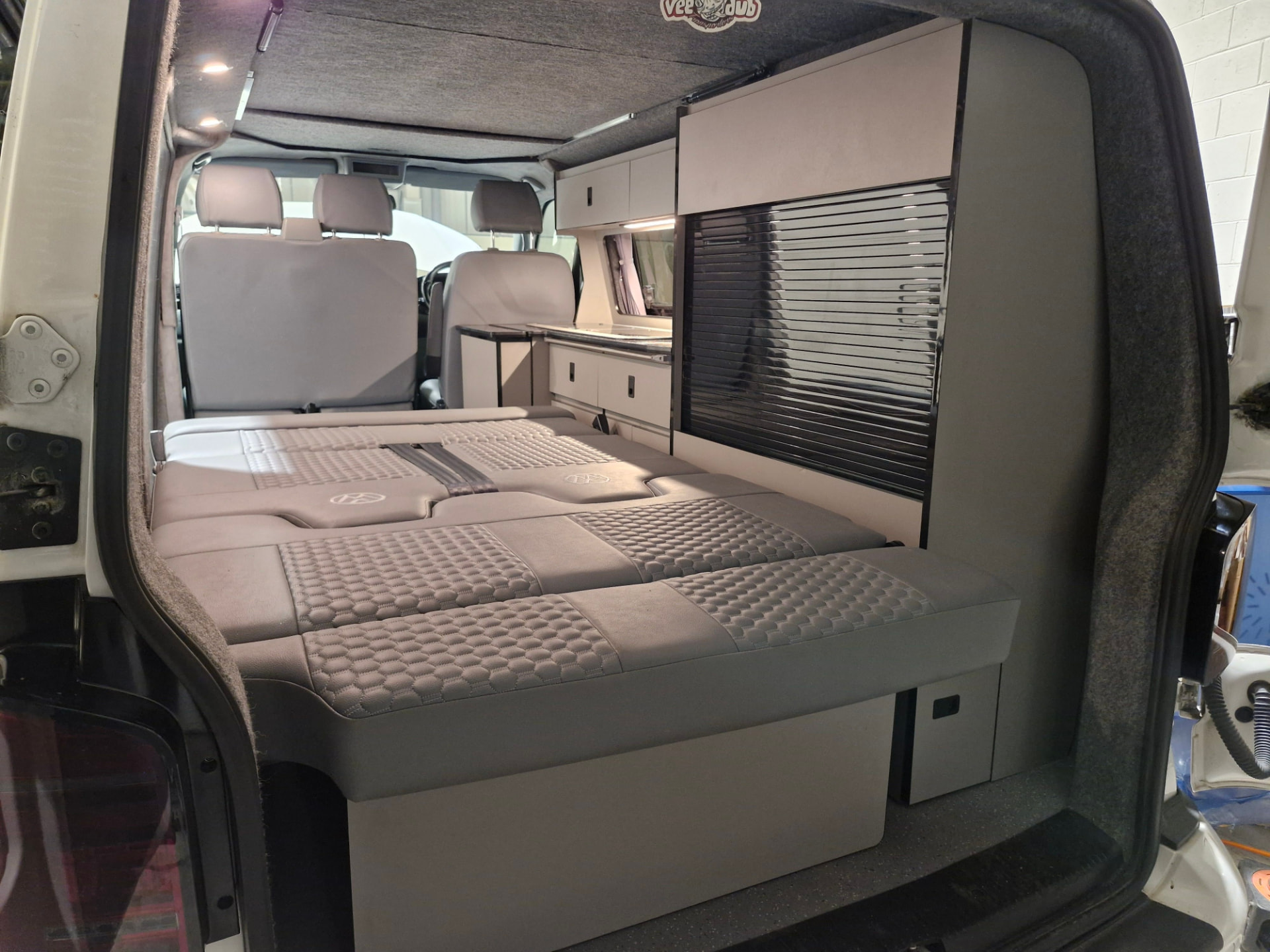 Three-quarter width rock and roll bed folded flat into a sleeping platform