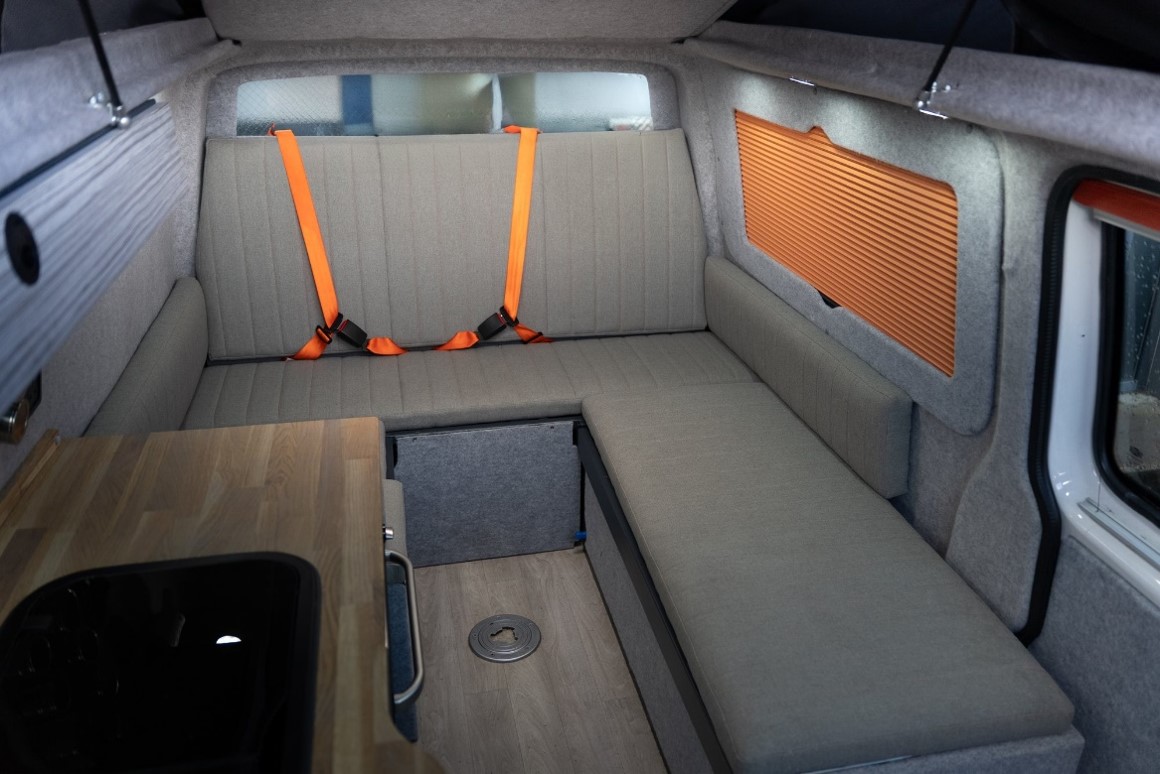 U-shaped rear lounge seating in a VW Transporter with belted rear travel seats and a side worktop